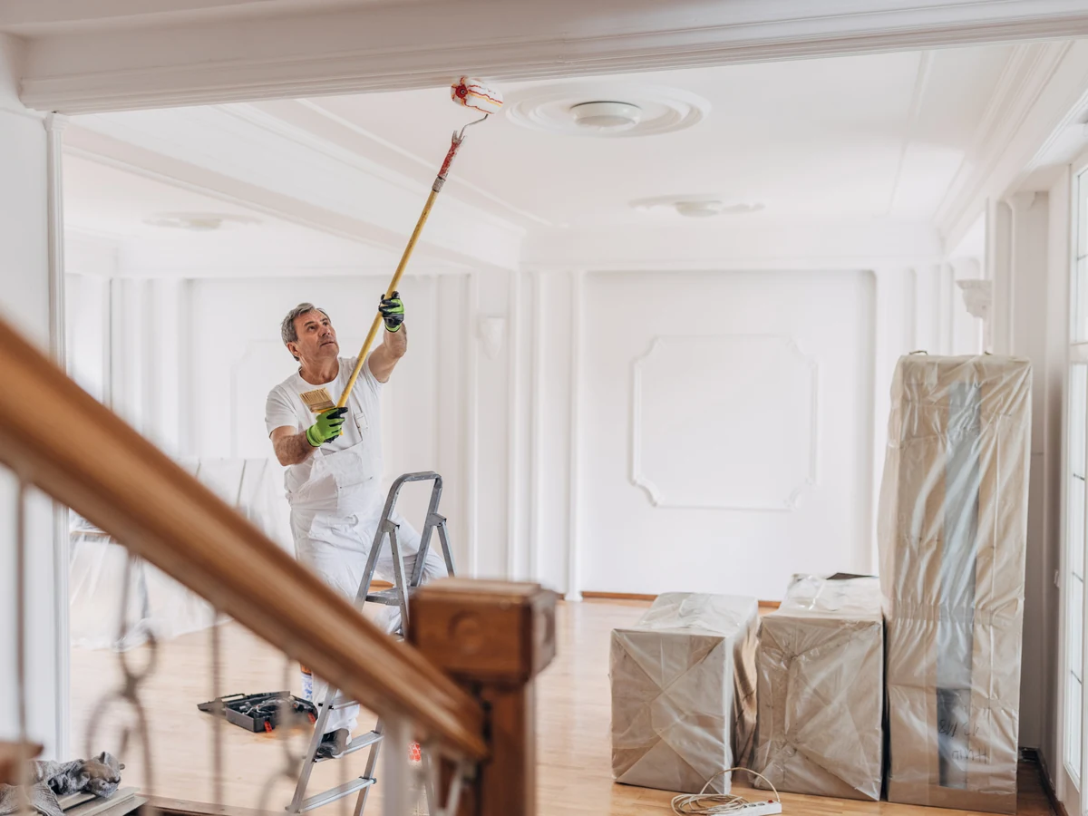 Ceiling painting in Altrincham - painter applying white ceiling paint by Altrincham Decorators