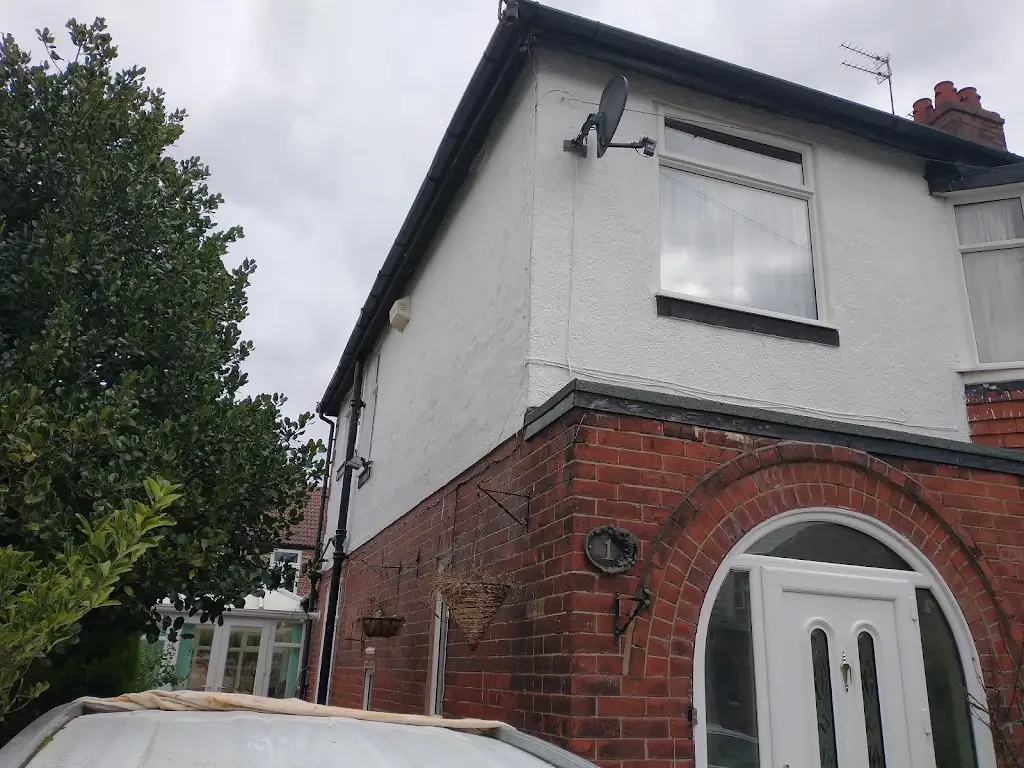 Freshly painted white exterior masonry and black trim by Altrincham Decorators.