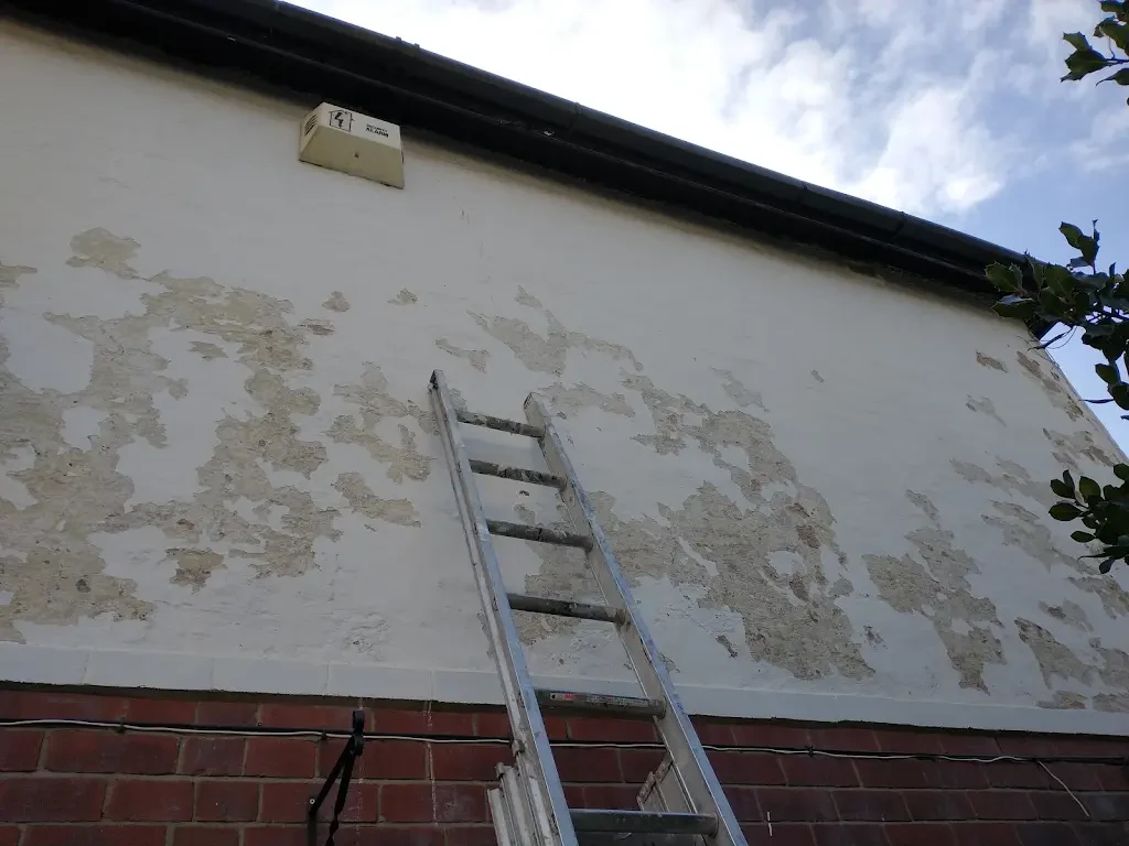Weathered and flaking exterior masonry before preparation and repainting by Altrincham Decorators.