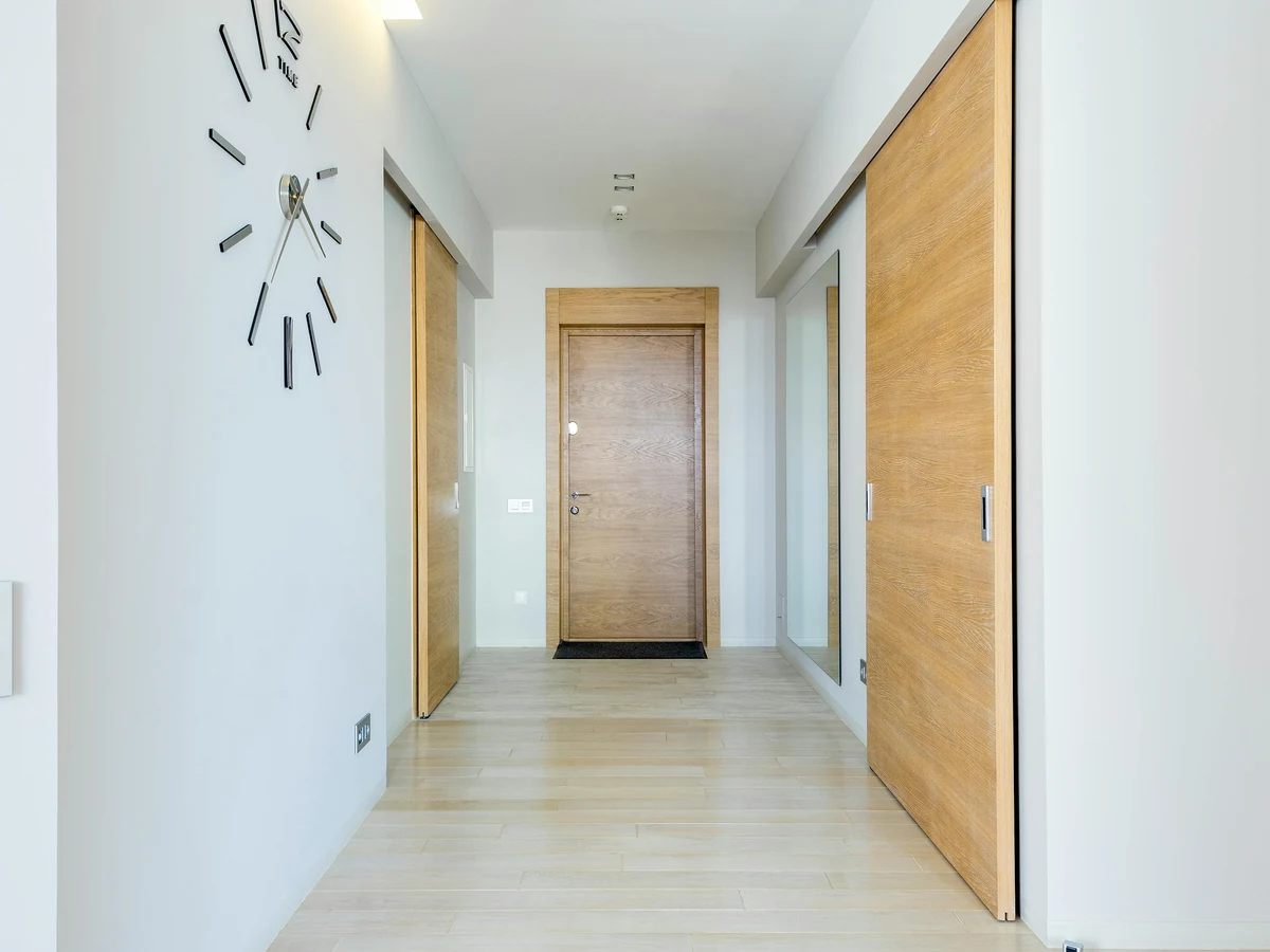 White hallway with wood flooring painted by Altrincham Decorators