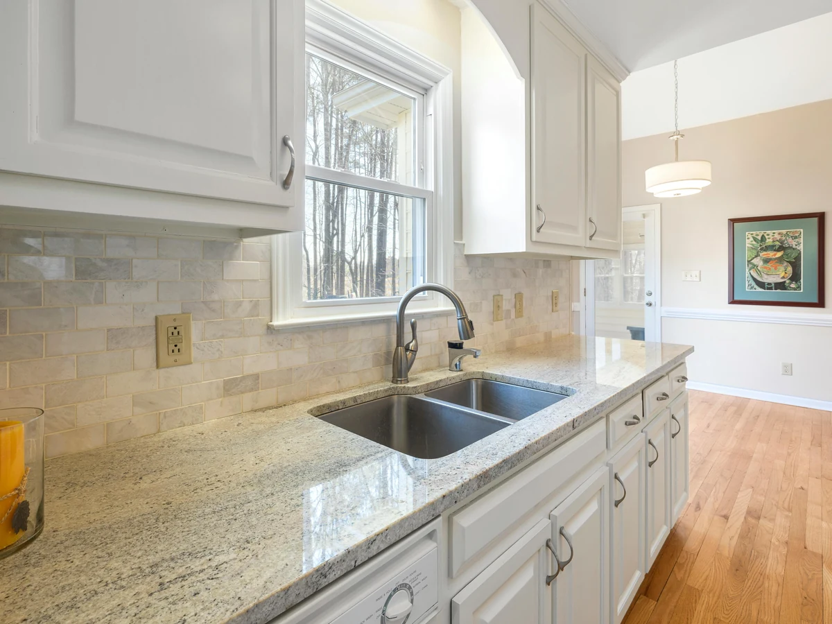 White kitchen cabinets with granite worktop painted by Altrincham Decorators