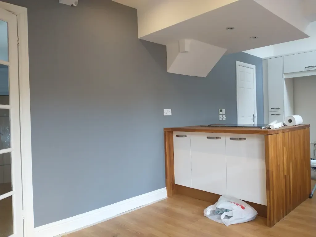 Open-plan room with smooth grey walls and crisp white trim, painted by Altrincham Decorators.