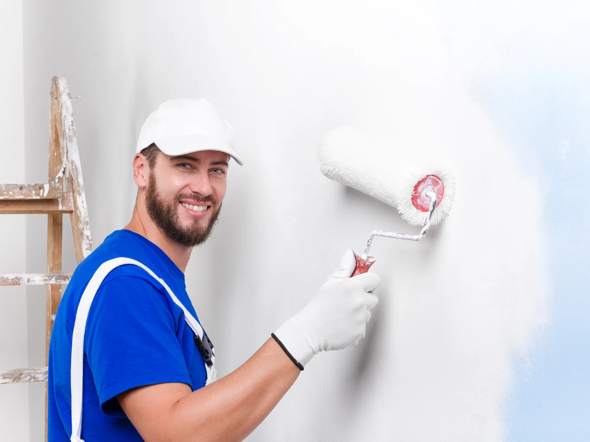 painting-decorating-smiling-painter-blue-altrincham-decorators Professional painter ready for front door painting work in Altrincham